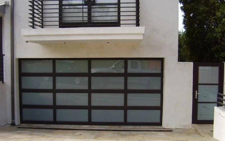 Contemporary home with a frosted glass garage door featuring a sleek matte black frame, alongside a matching pedestrian gate, set against a minimalist white exterior with modern architectural elements